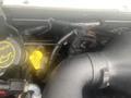 Close-up view of the engine compartment of a 2004 Ford Econoline showing various components and hoses