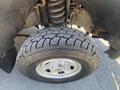 Close-up of a large tire with a rugged tread design mounted on a silver alloy wheel from a 2016 Ford F-350 SD
