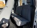 The interior of a 2011 Ford F-350 SD showing the rear bench seat with gray fabric upholstery and seatbelts attached