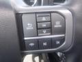 Close-up of a steering wheel control panel featuring buttons for navigation and media functions on a 2022 Ford F-150