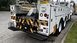 A 2006 International 7500 truck with a white body featuring yellow and black caution stripes and various mounted equipment on the rear