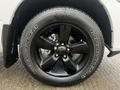 Close-up of a black alloy wheel on a 2022 RAM 1500 Classic featuring Goodyear Wrangler tires with bold white lettering on the sidewall