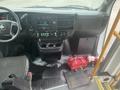 Interior view of a 2017 Chevrolet Express showcasing the dashboard steering wheel and console with controls and storage compartments