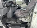 Interior view of a 2008 Ford Econoline showing the driver's seat covered in a black protective cover and the dashboard with various controls and features