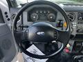 The interior view of a 2011 Ford F-750 showing the steering wheel dashboard with various gauges and controls