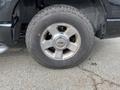 Close-up of a tire on a 2004 Ford Explorer Sport Trac featuring a silver alloy wheel and a rugged tread pattern