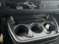 A 2012 Chevrolet Express interior showing a console with three cup holders and exposed wires in the dashboard area