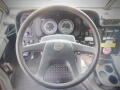 Steering wheel and dashboard of a 2008 Freightliner MT45 Chassis featuring gauges controls and an assortment of buttons and switches