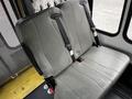 The image shows a pair of grey bench seats in a 2016 Ford Econoline with seat belts attached to the seat backs
