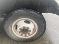 Close-up of a wheel and tire from a 2012 Ford Econoline showing the tire tread and a metal rim with six lug nut holes