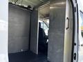 Interior view of a 2022 Ford Transit showing a partition wall separating the cargo area from the driver’s seat area with a single chair visible