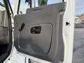 Interior door panel of a 2011 International 4300 featuring a gray design with a handle and a small window control