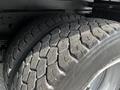 Close-up of two tires belonging to a 2015 Mitsubishi Fuso FE showing detailed tread pattern and wear marks