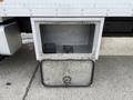A silver metallic storage compartment with a hinged door is open, revealing a spacious interior without any items inside