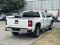 A white 2016 GMC Sierra 1500 pickup truck with a four-wheel drive badge on the tailgate and chrome accents on the rear and sides
