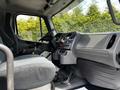Interior view of a 2010 Freightliner M2 106 showing the driver's seat dashboard and controls with a focus on the steering wheel and gear shift