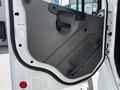 Interior door panel of a 2012 Freightliner M2 106 featuring a gray finish with a handle and a safety warning label visible