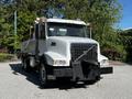 A 2005 Volvo VND 122 truck with a silver body and a large dump bed is positioned front-facing with a black bumper and multiple lights on the roof