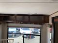 Interior view of a 2016 Jayco 265RLSW showing overhead cabinets with empty shelves and a window below letting in natural light
