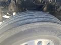 Close-up of the tire of a 2008 Peterbilt 340 showing tread patterns and the metal rim in the foreground