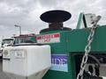 A green 2011 Hightliner Aquacide Hot Water Weed Control Dual Flat Deck Trailer with a hot water tank and a caution sign indicating high temperature