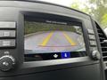 A 2023 Mercedes-Benz Metris dashboard display showing a reverse camera view with yellow guidelines on a parking surface