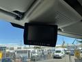 A monitor mounted on the ceiling of a vehicle's interior displaying a black screen