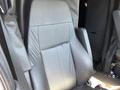 A black leather driver's seat from a 2022 Freightliner Cascadia with textured fabric and visible wear on the cushion