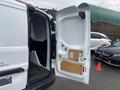 A 2017 Ford Transit Connect with the rear door open showing the cargo area and interior features such as wall paneling and levers