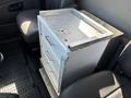 A metal storage cabinet with four drawers is placed in the front seat area of a 2008 International 7500 truck