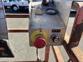 Control panel of a 2010 SkyJack SJ featuring a large red emergency stop button a yellow toggle switch and a black power switch