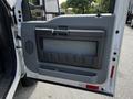 The image shows the interior door panel of a 2016 Ford F-550 featuring a large handle and a storage compartment with a textured surface