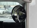 A 2020 Chevrolet Express is reflected in a round side mirror inside the vehicle with visible seats in the foreground