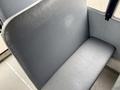 A gray bench seat typical of a school bus designed for passenger comfort with a smooth finish and simple design