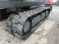 A close-up view of a tracked system of a 2022 Hyundai R55-9A showing the heavy-duty rubber tracks and wheel assembly