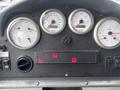 Dashboard of a 2006 E-One Typhoon featuring several gauges for coolant, voltage, RPM, and fuel with indicator lights and control switches