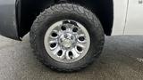 Close-up of a chrome wheel with multiple spokes and a Chevrolet logo on a 2013 Chevrolet Silverado 1500 equipped with all-terrain tires