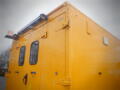 A yellow 2008 Freightliner MT45 Chassis featuring a rear view with large windows and light fixtures on the roof