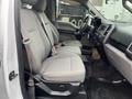 Interior of a 2016 Ford F-150 showing two front seats with gray fabric upholstery and seat belts in place