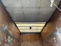 Interior view of the cargo area of a 2015 Hino 195 featuring wooden walls a metal floor and a partially opened roof with visible supports