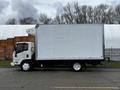 A 2018 Isuzu NRR truck with a white box cargo area parked on a street with a visible side profile and no additional markings or graphics on the truck surface