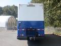 A blue and white 2008 Peterbilt PB340 truck with a large cargo box and rear door facing the viewer