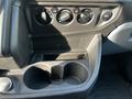 Interior console of a 2017 Ford Transit featuring climate control knobs and cup holders