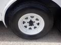 White wheel with five circular openings and a black tire on a trailer