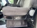 A close-up of the seat mechanism of a 2013 Kenworth T370 showing the seat cushion and adjustment lever