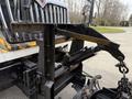 Close-up of the front hydraulic lift mechanism of a 2016 International 7600 truck showing the arm and chain attachments