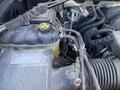 Engine compartment of a 2014 GMC Sierra 1500 featuring various components including hoses wires and a reservoir tank