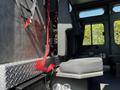 Interior view of a 2006 Emergency One Fire Truck showing a seat with a red safety strap attached to a metal frame and flooring with a diamond plate surface