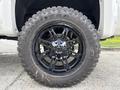A black wheel with a multi-spoke rim design mounted on a large off-road tire marked with Goodyear and mud terrain tread detailing