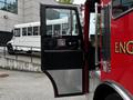 A red 1991 Sutphen Deluge fire truck with a black door slightly open showcasing the interior dashboard and controls